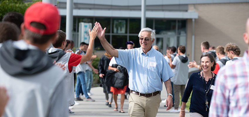 A student and professor exchanging a high five at Academic Convocation