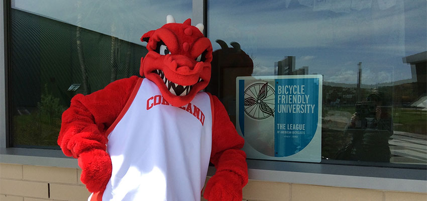 Blaze standing by Bike Friendly University sign