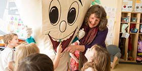 Professor and students with tooth mascot