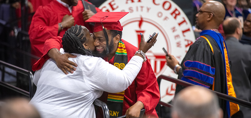 A woman hugging her son at graduation