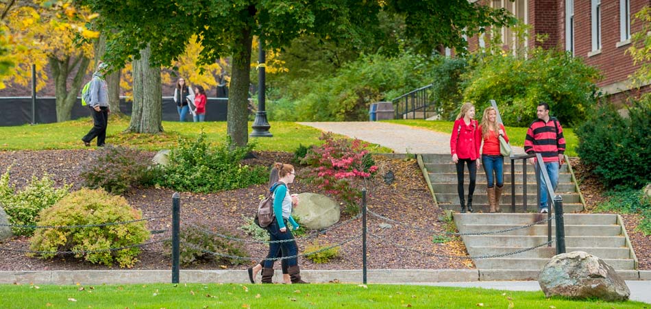 Students walking on campus by landscaping