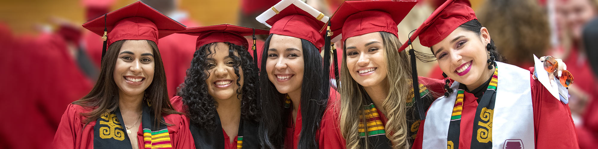 Group of five students smiles in a camera-aware photo during Commencement