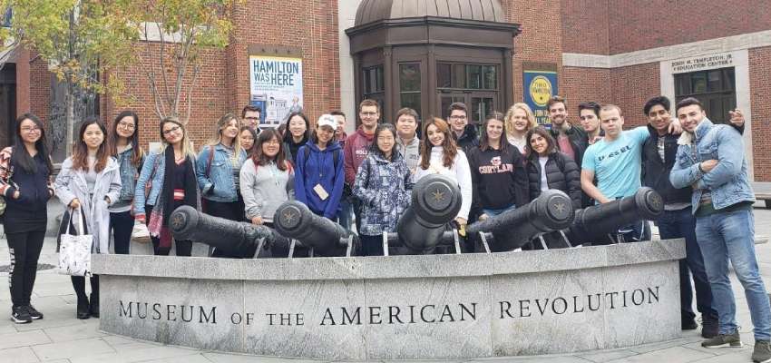 Students standing together in front of museum