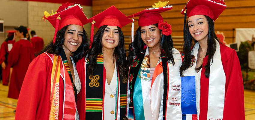Four students stand together in Corey Gymnasium before 2022 Undergraduate Commencement