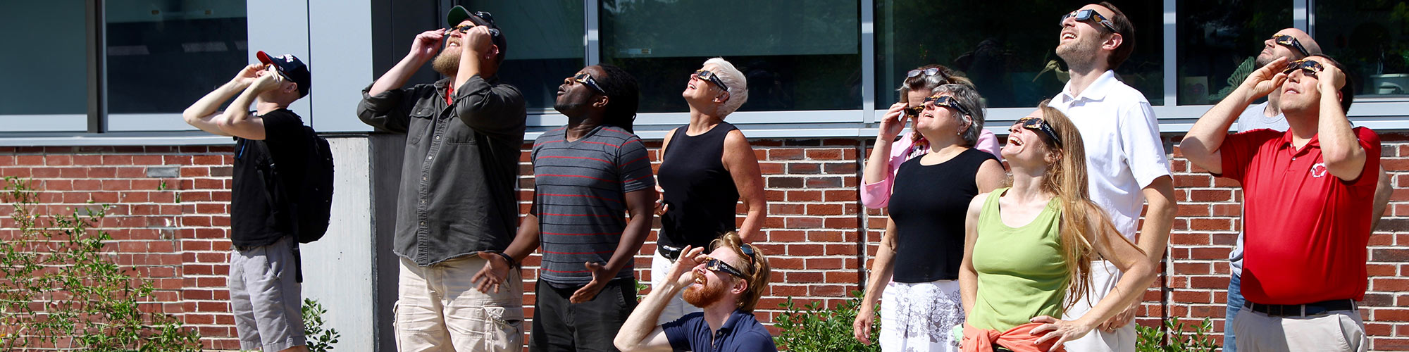 Crowd of people wearing safety glasses, gather to watch the solar eclipse in 2017.