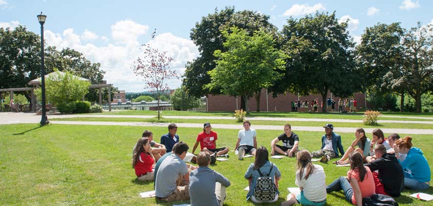 Orientation group sitting on the lawn outside of Sperry Center