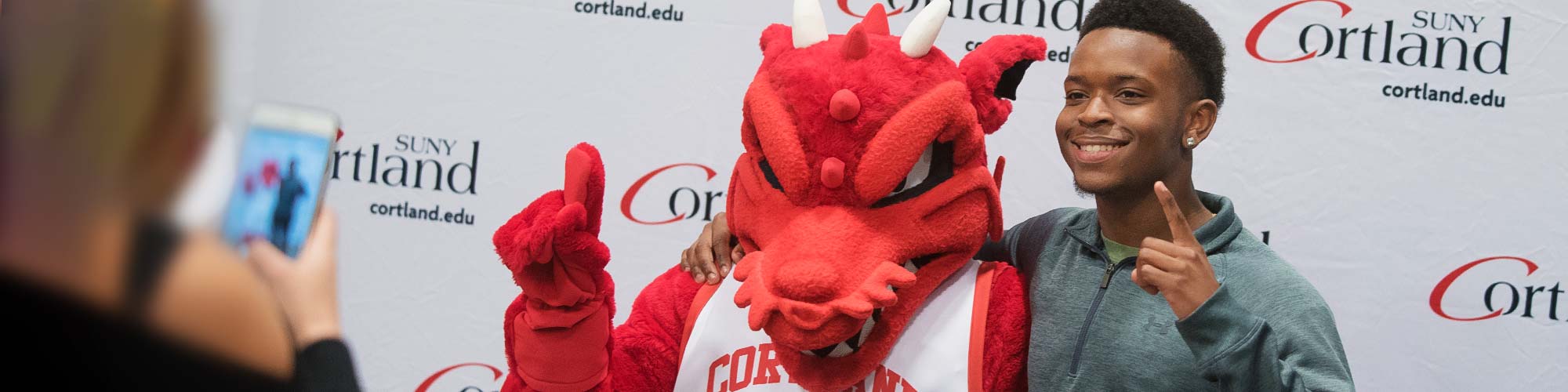 Student and Blaze posing for a photo at Spring Open House