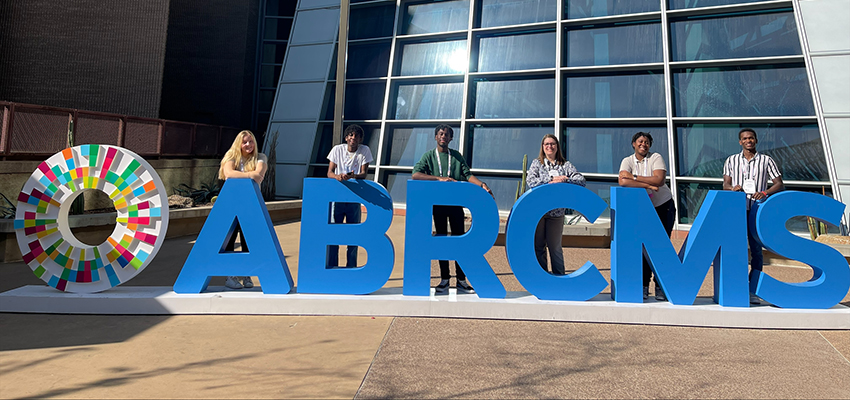 Five LSAMP students pose near large letters at the ABRCMS meeting in Phoenix, an opportunity for underrepresented students in STEM to learn about professional development