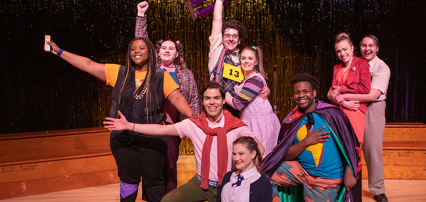 Spelling Bee musical cast smiles on stage