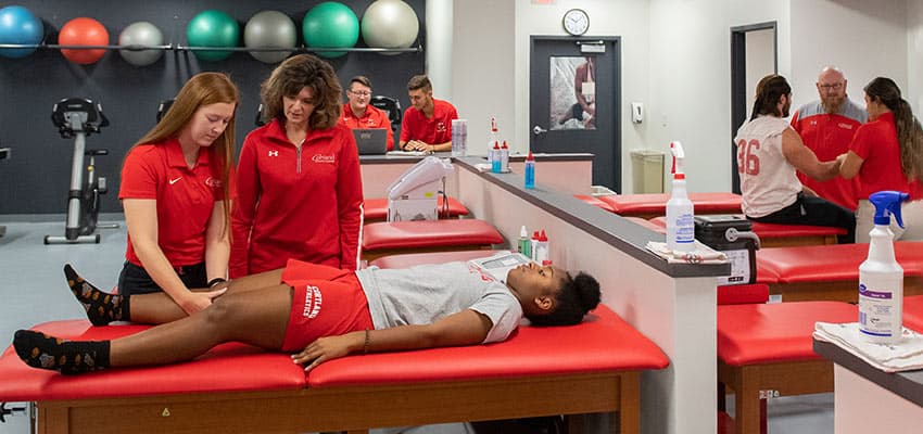 Kinesiology student assessing student-athlete in Sports Medicine Symposium