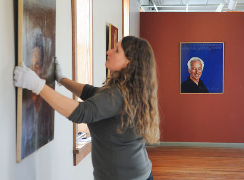 Jaroslava Prihodova, the Dowd Gallery's manager, preps for the "Americans Who Tell the Truth" exhibition. The portrait of Bill Griffen can be seen in the background.