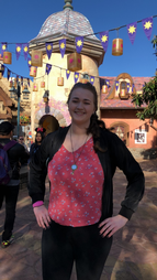 Molly standing and smiling at the camera at Disney World