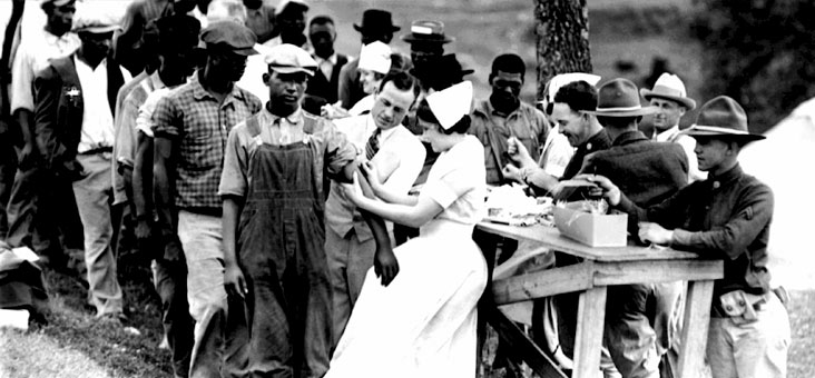 Black men in line for the Tuskegee syphilis study as white doctors and nurses inject them