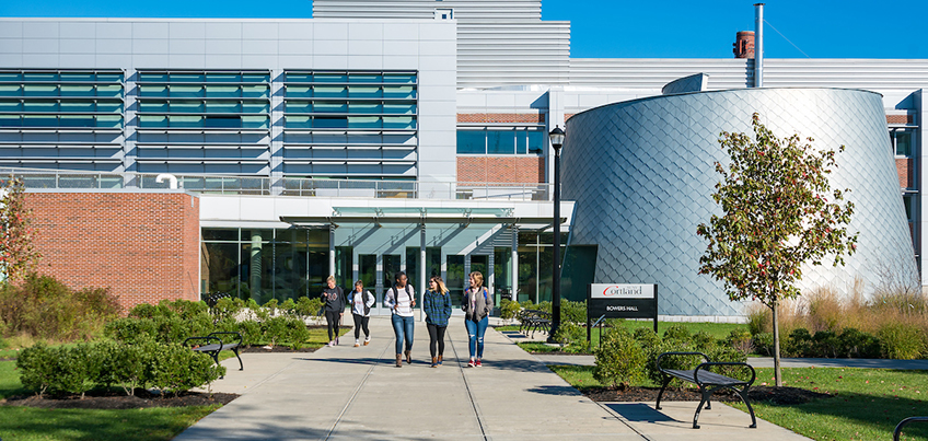 Exterior view of students walking outside Bowers Hall, SUNY Cortland's science facility, on a fall day