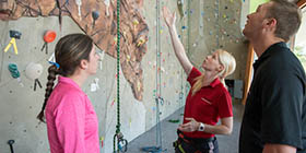 professor and students at the climbing wall