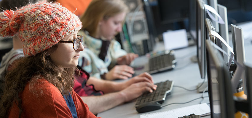 Students individually working on writing projects in a computer lab