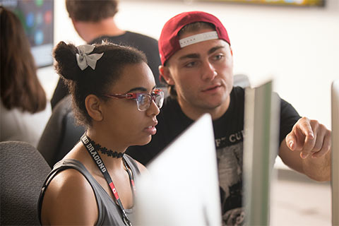 Two students working together in front of a computer 