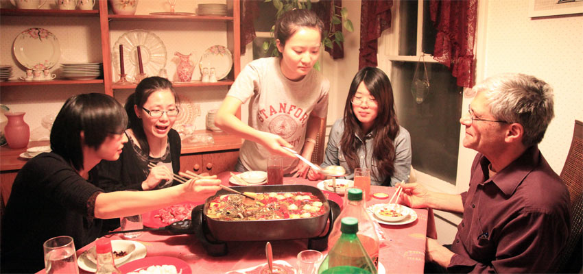 International Students Sharing a Traditional Dinner with Host Family