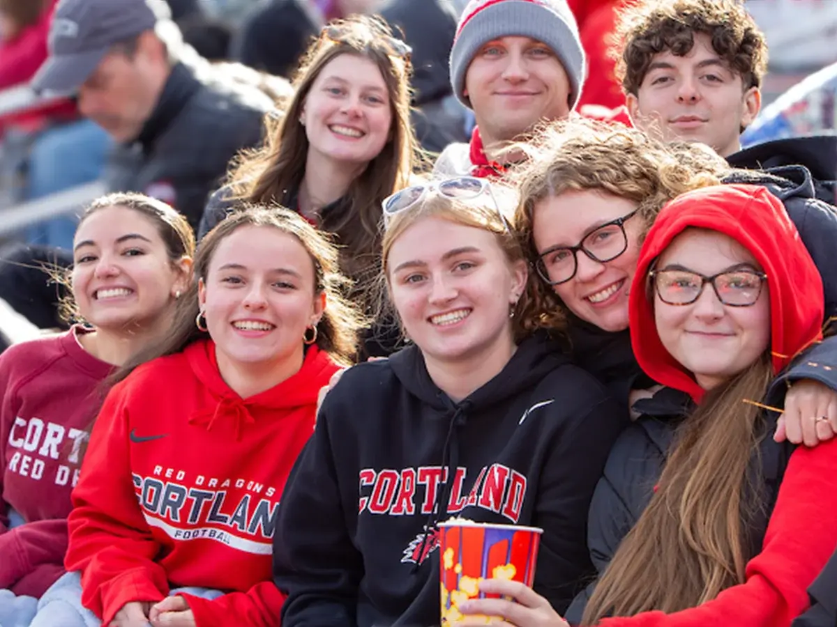 Family wearing Cortland gear at Family Weekend football game