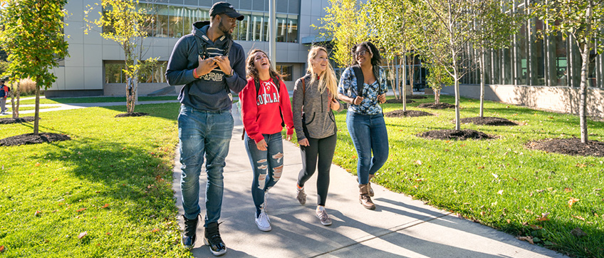 Laughing students walk together outside of the Student Life Center