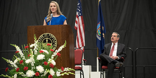 Student Government President speaks with SUNY Cortland President Erik Bitterbaum in the background.