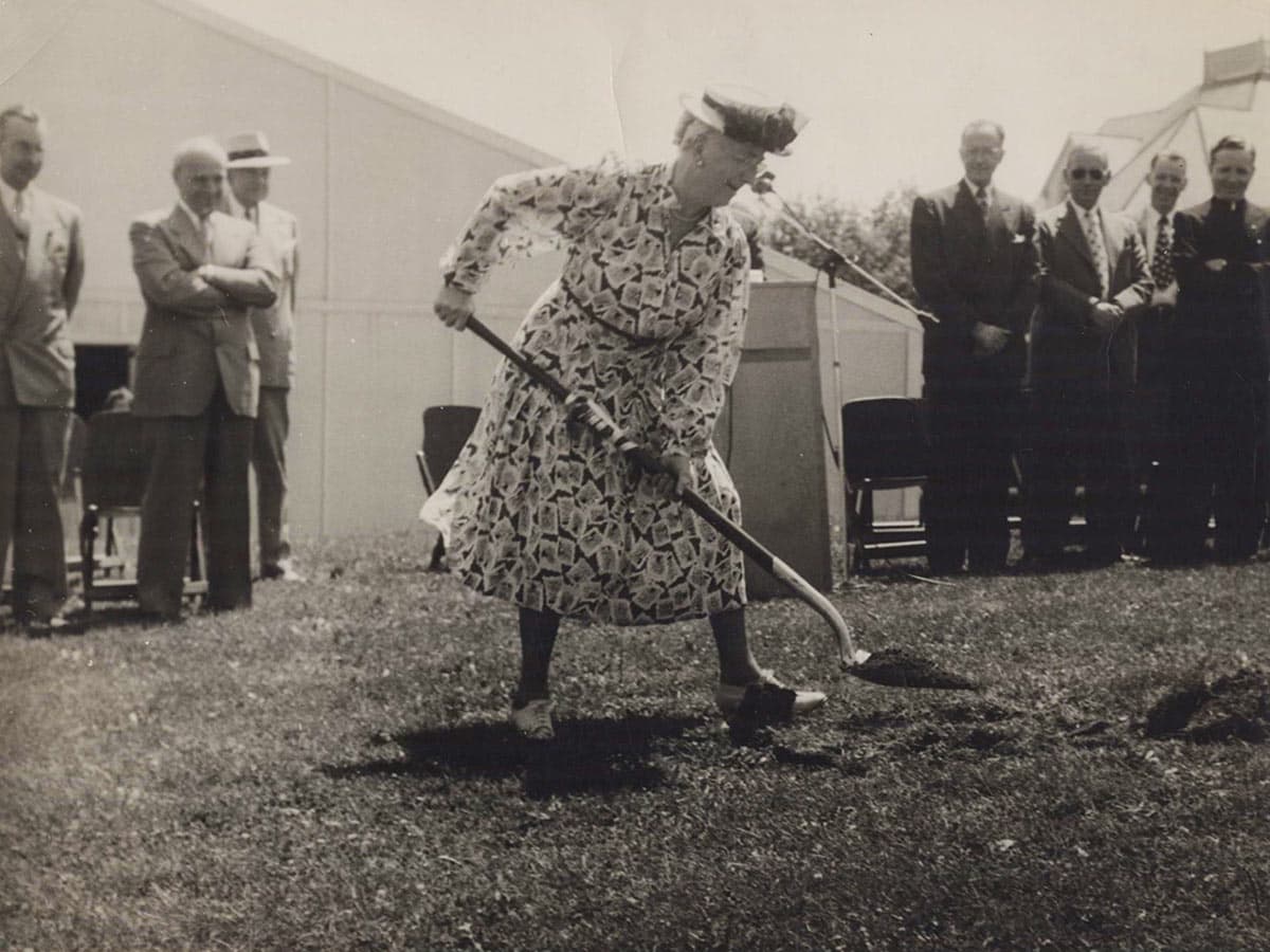 Historic black and white photo of Bessie Park with a shovel breaking ground on a new campus building.