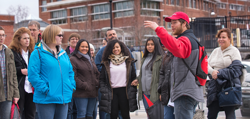 Student tour guide showing families around the campus.