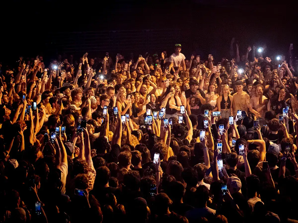 Cortland students holding cell phones in the air at a Spring Fling concert