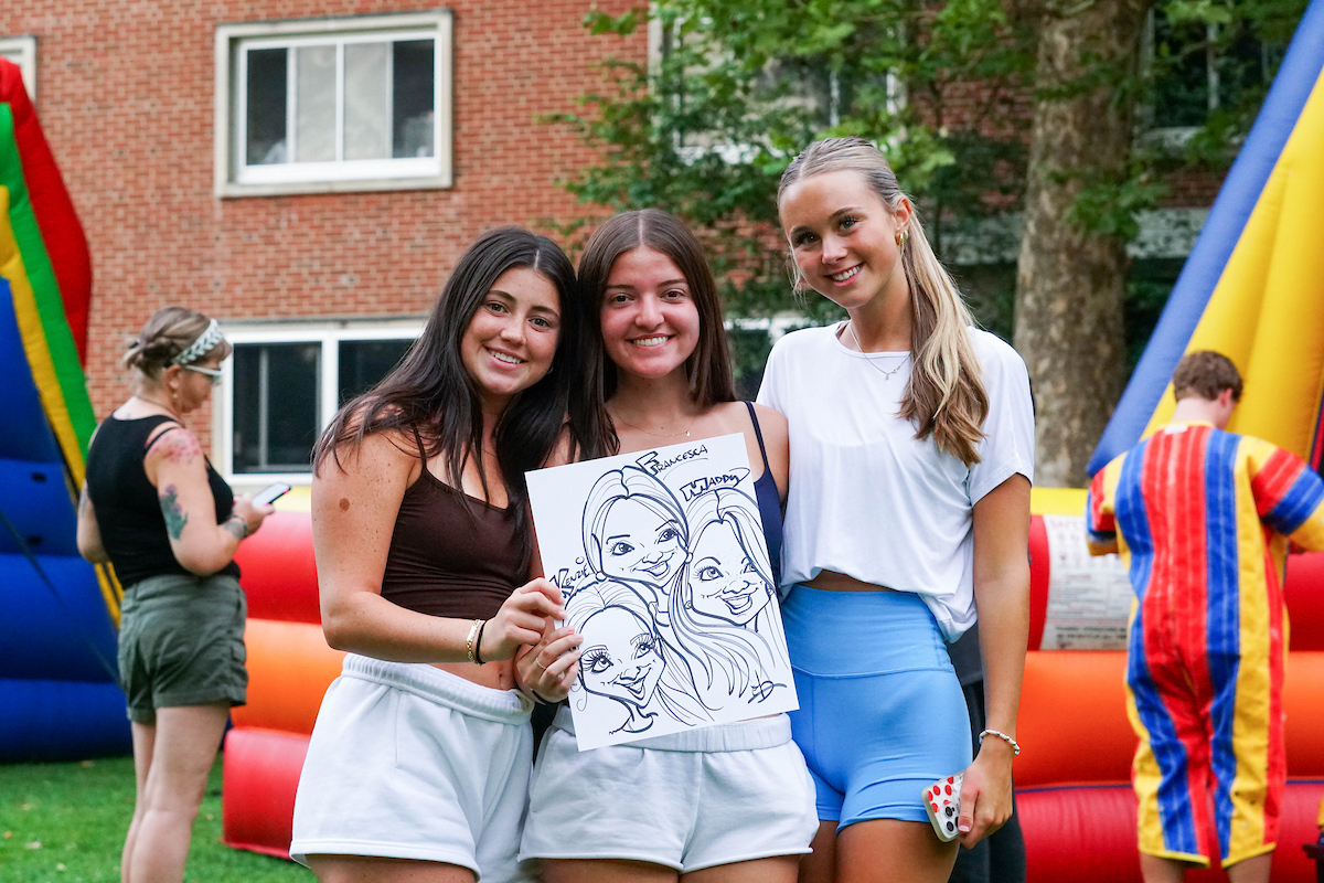 new students pose with their caricature drawing