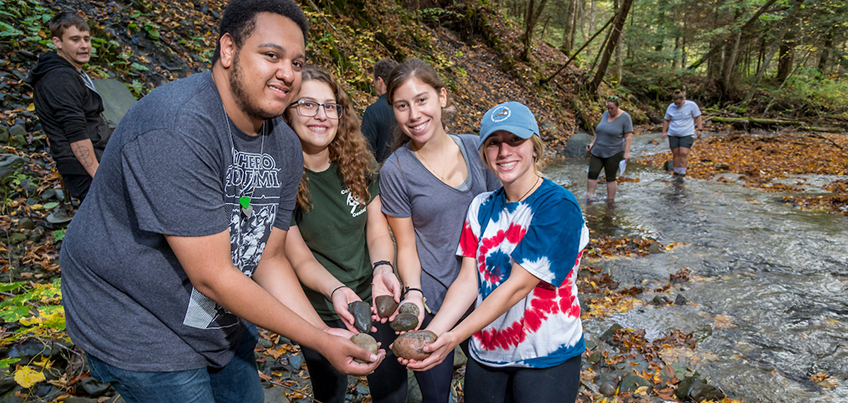 Geology students holding a rock during an outdoor education experience