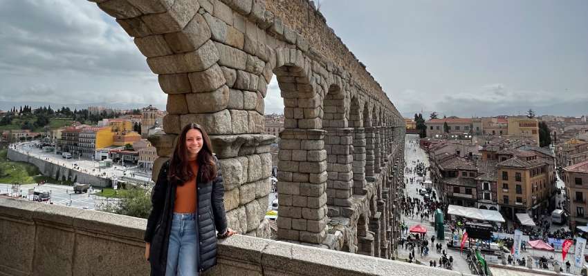 Student standing in front of an aqueduct in Spain