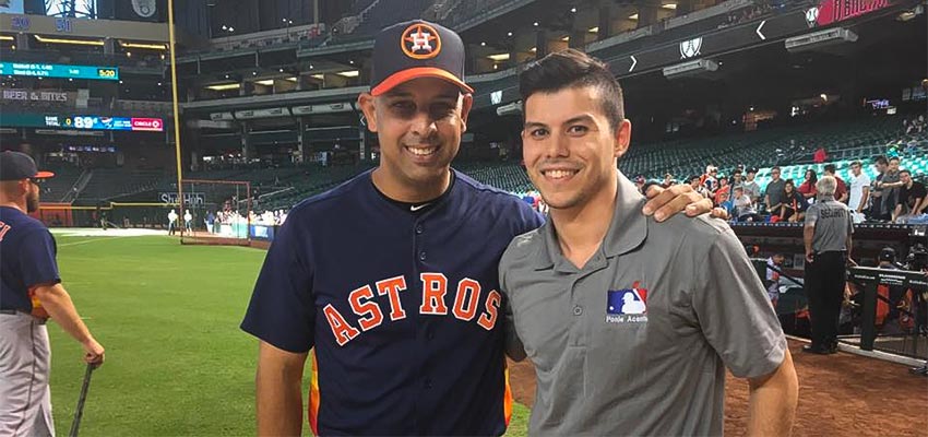 International Sport Management grad posing with Houston Astros player on a MLB field