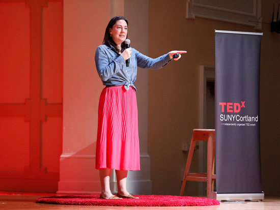 Woman speaking on the stage at 2024 SUNY Cortland TEDx event