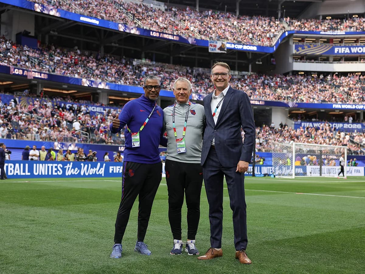 Mandelbaum stands on the field of the World Cup stadium with two gentlemen