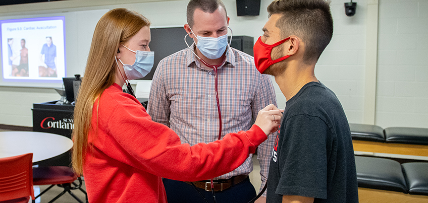 Student checks a classmate's heart rate in the athletic training classroom