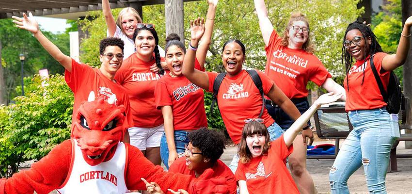 Blaze and a group of students all wearing Cortland red pose with arms up and open..