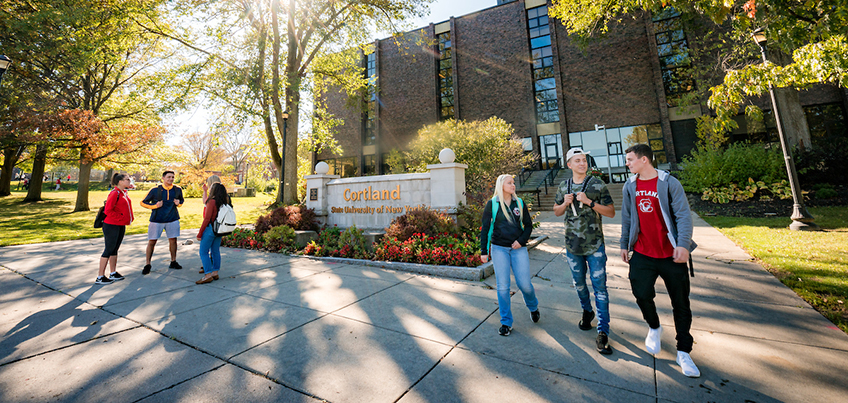 Students walking outside Miller Building sign