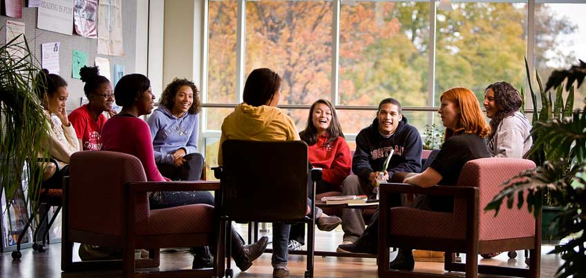 Education students sitting and having a group discussion with their professor