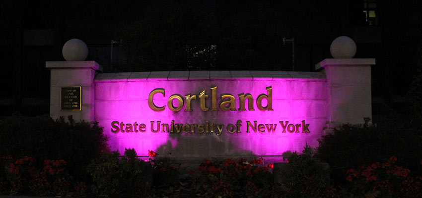 Sign in front of Miller Building illuminated in purple