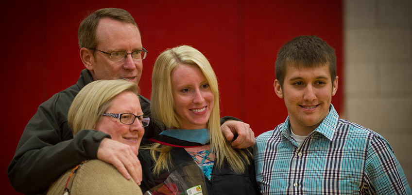 Graduate and family smile for a picture