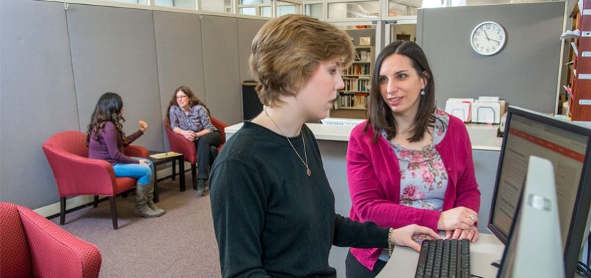 A Student and Professional Staff Person Collaborate at a Computer