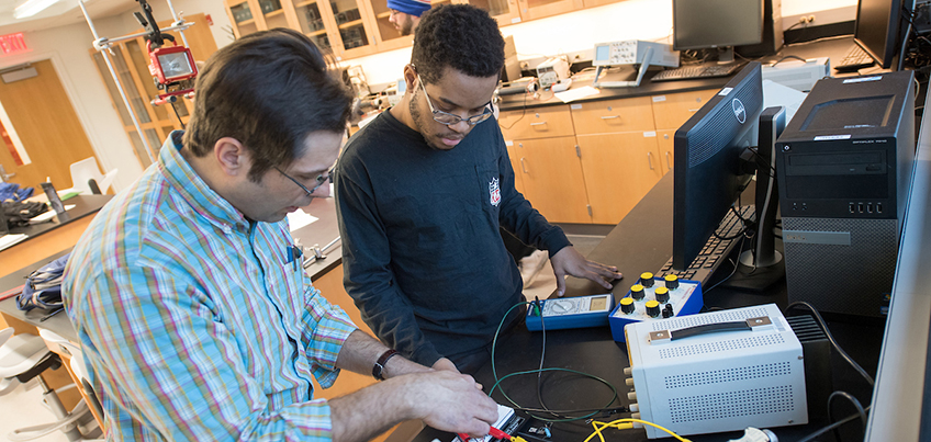 Student working with a faculty member in a physics lab