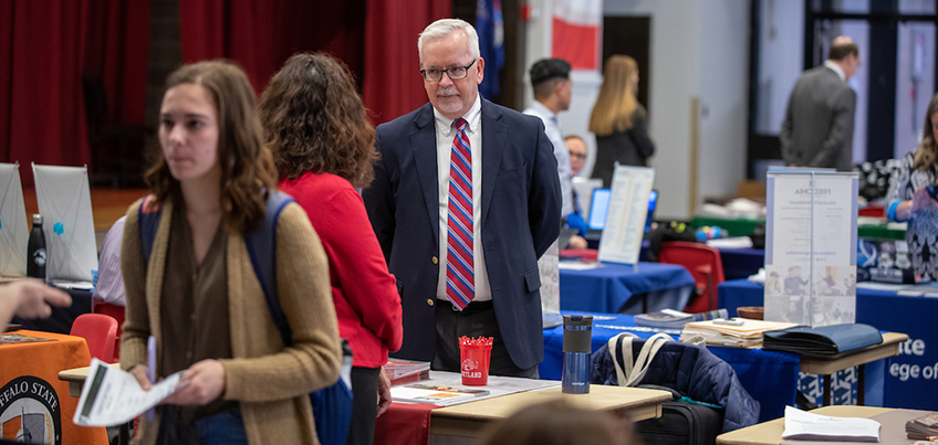 Admissions Office staff member speaks with a prospective graduate student on campus