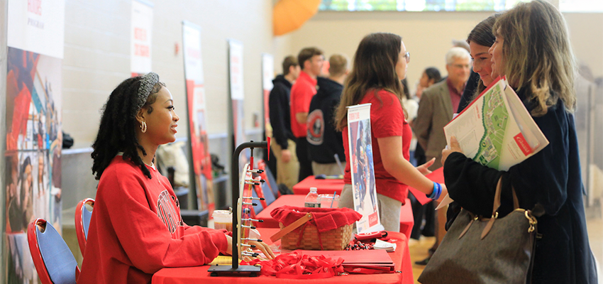 Student Government representative speaks with a prosepctive student and mother at the fall open house.