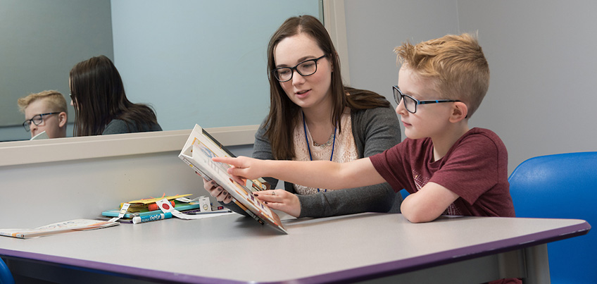 Student working with child at a table