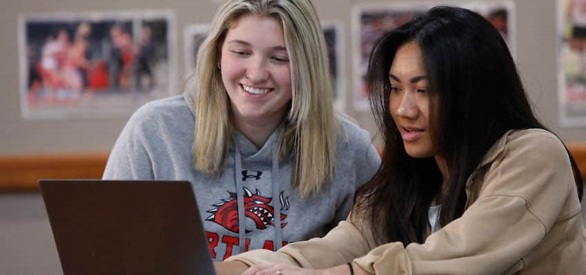 Two students working on a laptop.