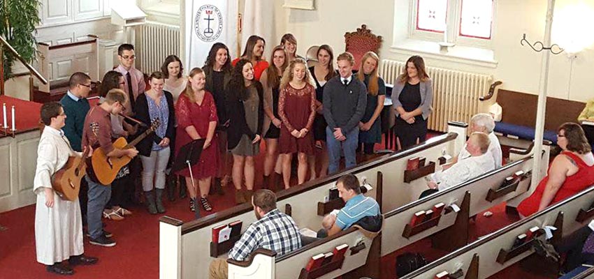 Students performing with Reverend Rachel Ditch at an Interfaith Service