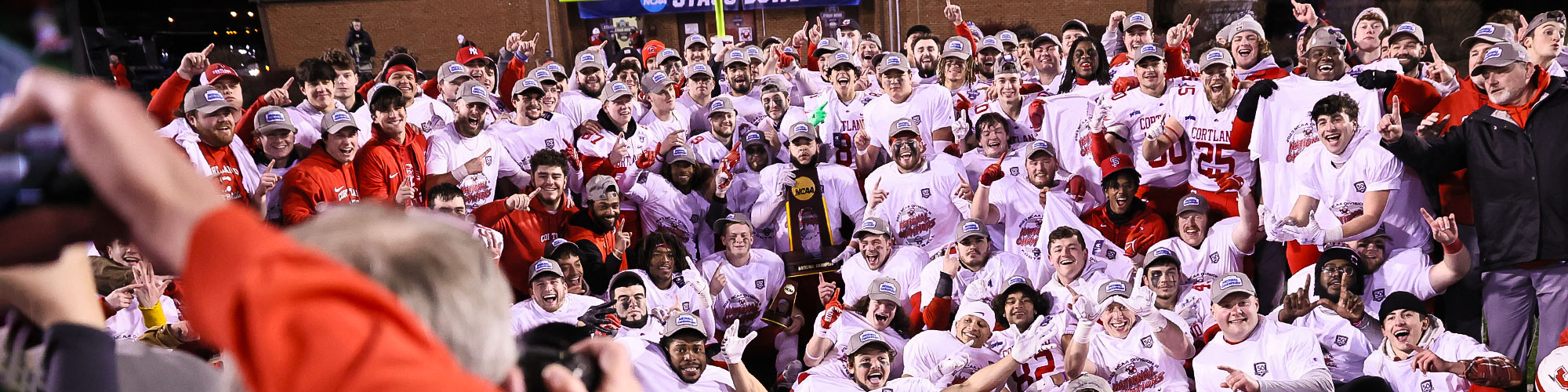 Football team holding the NCAA trophy after their win