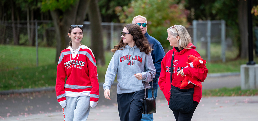 family walking on campus smiling while looking at each other and surroundings