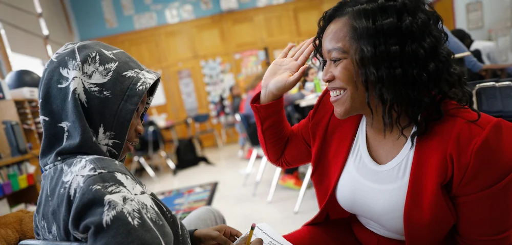 Teacher high fives student for good work